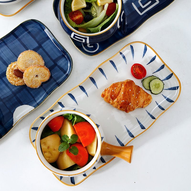 Assorted food items on ceramic plates with a white background